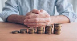 man sitting behind stacked coins